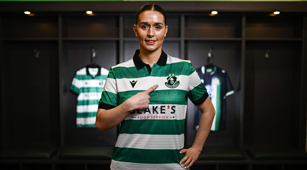 Shamrock Rovers female player in team jersey at locker room.